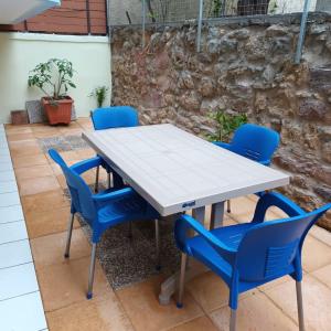 a table and chairs with blue chairs around it at Stelios apartment 2 in Chios