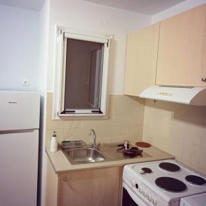 a small kitchen with a sink and a stove at Stelios apartment 2 in Chios