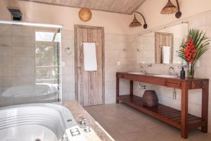 a bathroom with a tub and a sink at Villa Alema Luxury Beach House in Marau +50 photos