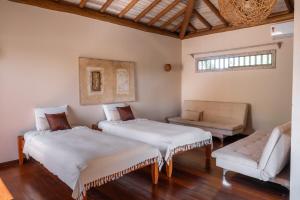 a room with two beds and a couch at Villa Alema Luxury Beach House in Marau