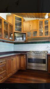 a kitchen with a stove top oven and a microwave at Daly View Bed & Breakfast in Fremantle