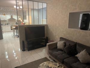 a living room with a couch and a flat screen tv at Maison appartement cosy au centre-ville in Luxeuil-les-Bains +10 photos