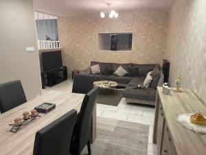 a living room with a couch and a table at Maison appartement cosy au centre-ville in Luxeuil-les-Bains