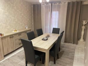 a dining room with a wooden table and chairs at Maison appartement cosy au centre-ville in Luxeuil-les-Bains