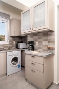 a kitchen with a washing machine and a microwave at Artemis Seaside House, With Sea View in Kalamaki Heraklion