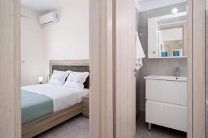 a bedroom with a bed and a bathroom with a sink at Artemis Seaside House, With Sea View in Kalamaki Heraklion