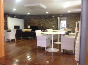 a living room with a table and white chairs at Quinta dos Castanheiros - Turismo Rural in Negreda