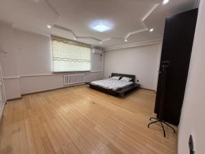 ein Schlafzimmer mit einem Bett in einem Zimmer mit Fenster in der Unterkunft Villa Mountain Medeu in Almaty