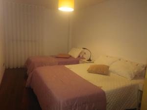 a hotel room with two beds and a lamp at AL Mirador in Aveiro