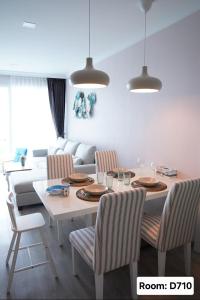 a dining room with a table and chairs and a couch at My Resort Hua Hin - by Great Days in Hua Hin