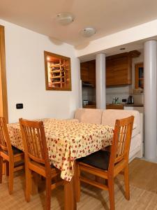 mesa de comedor y sillas con mesa y sofá en Vila Anđelija, en Jahorina