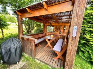 a wooden gazebo with a bench and a table at Ferienwohnung mit Gartennutzung, Garage und Wallbox in Habrachćicy