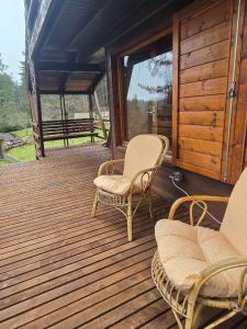 a porch with two chairs and a bench on a house at Chalet Natura Il rifugio dello scoiattolo in Cavaliere