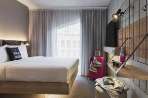 a hotel room with a bed and a window at Moxy Lausanne City in Lausanne +22 photos