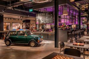 Un viejo coche verde aparcado en un restaurante. en Moxy London Heathrow Airport, en Hounslow