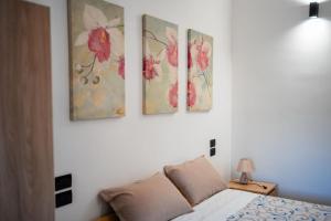 a bedroom with four paintings on the wall at Kalispera Aster in Melito di Porto Salvo