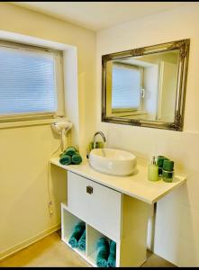 a bathroom with a sink and a mirror at Modern apartment in Albstadt +12 photos