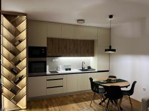 Una cocina con una mesa y sillas en una habitación. en Apartman Vidik Spa & Gym Zlatibor, en Zlatibor