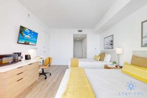 a hotel room with a bed and a tv at Amazing Studio Near the Beach in Hallandale Beach