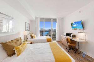 a hotel room with a bed and a desk and a deskablish at Amazing Studio Near the Beach in Hallandale Beach +32 photos