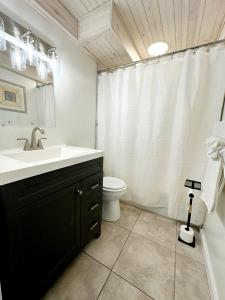 a white bathroom with a sink and a toilet at Aqua Villa Condo 204 Beachfront in Fort Walton Beach +7 photos