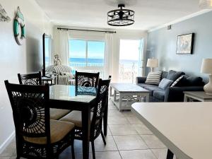 a kitchen and living room with a table and chairs at Aqua Villa Condo 204 Beachfront in Fort Walton Beach