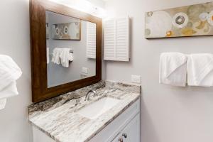 a bathroom with a sink and a mirror and towels at Plantation West #1348 in Gulf Shores