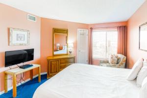 a bedroom with a white bed and a television at Plantation West #1348 in Gulf Shores +25 photos