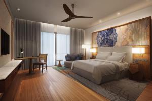 a bedroom with a large bed and a desk and a table at The Westin Desaru Coast Resort in Desaru