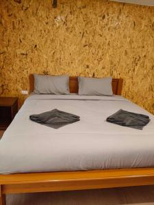 a bed with two towels sitting on top of it at House by the Stream in Ko Lanta Yai
