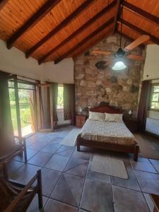 a bedroom with a bed and a stone wall at Las Veronas in Villa de Las Rosas