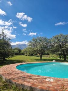 a swimming pool with a brick path around it at Las Veronas in Villa de Las Rosas