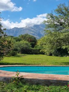 a swimming pool in a field with mountains in the background at Las Veronas in Villa de Las Rosas +7 photos