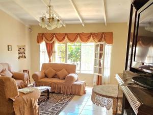 a living room with a couch and a window at Casa Familiar "Chiqui" in Cochabamba