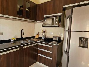 a kitchen with wooden cabinets and a stainless steel refrigerator at Casa Familiar "Chiqui" in Cochabamba