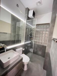 a bathroom with a toilet and a sink and a shower at Ngumbara House in Tasikmalaya