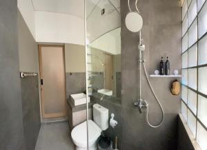a bathroom with a toilet and a shower with a mirror at Ngumbara House in Tasikmalaya +39 photos