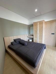 a bedroom with a large black bed in a room at Ngumbara House in Tasikmalaya