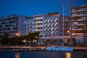 a boat in the water in front of a hotel at Moxy Patra Marina in Patra