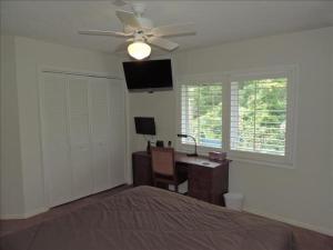 a bedroom with a bed and a desk and a ceiling fan at Big pool, 10 minute walk to beach, luxurious bath in Marco Island