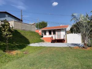 a small house on a hill next to a yard at Tiny Garden House in Santa Rita do Sapucaí