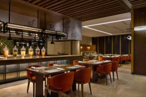 een restaurant met tafels en stoelen en een keuken bij Grand New Century Hotel, Hangzhou Boao, A Tribute Portfolio Hotel in Hangzhou