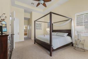 a bedroom with a canopy bed and a ceiling fan at Villa Azurro, Cape Coral in Cape Coral +90 photos