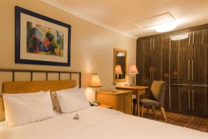 a bedroom with a bed and a desk and a chair at Protea Hotel by Marriott Dar es Salaam Oyster Bay in Dar es Salaam +23 photos