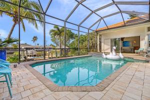 an indoor swimming pool with a glass ceiling and a house at Villa Azurro, Cape Coral in Cape Coral