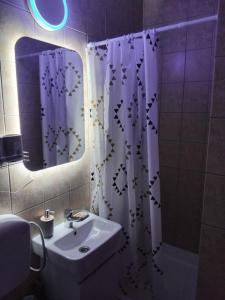 a bathroom with a sink and a shower curtain at AK apartman in Sutomore