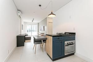 弗洛里亚诺波利斯WI-FI 200MB | Rooftop com Piscina e VistaMar #CA70的一间厨房,在房间内有一个蓝色的小岛
