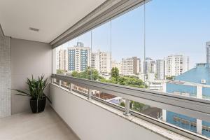 弗洛里亚诺波利斯WI-FI 200MB | Rooftop com Piscina e VistaMar #CA70的阳台设有大窗户,享有城市景观。