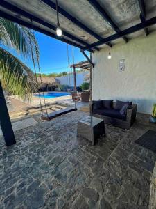 a patio with a couch and a view of a pool at Casa a pasos del mar de Playa el Agua in La Loma