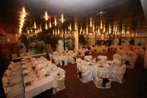 a room filled with tables with white linens and chandeliers at Hotel Lovech in Lovech